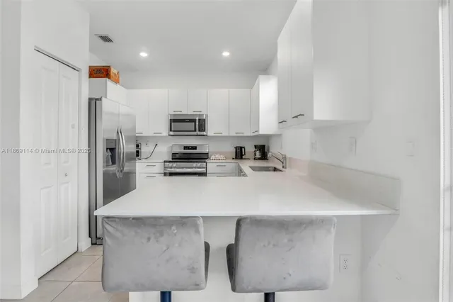 a kitchen with kitchen island a sink stove and refrigerator