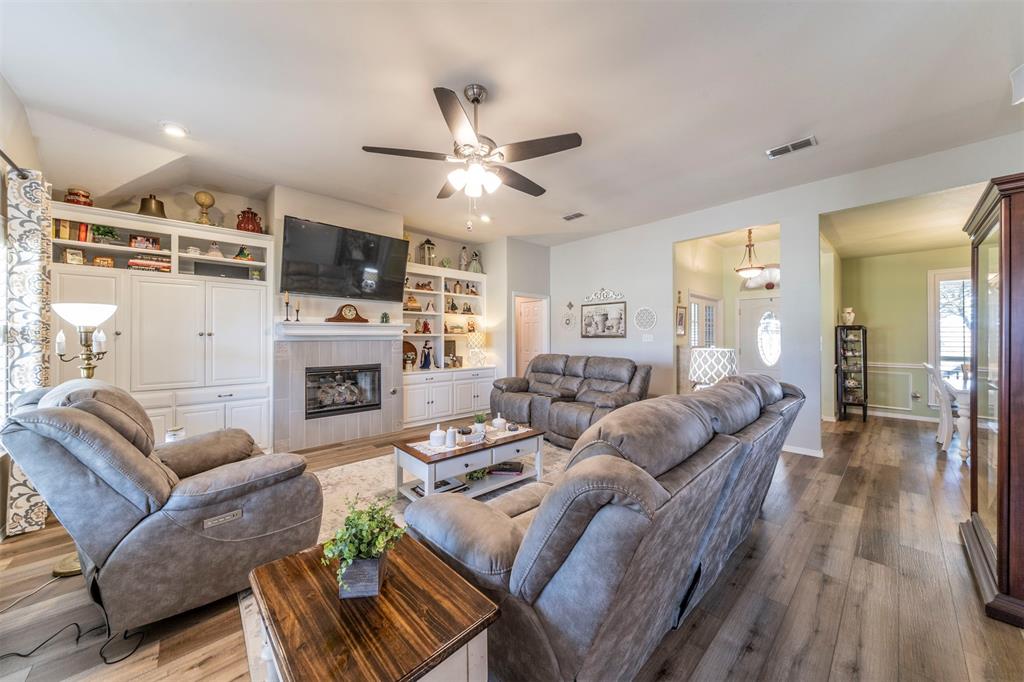 a living room with furniture a fireplace and a flat screen tv