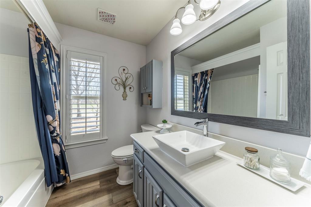 11621 Willow Springs Road Fort Worth, TX 76052 - Photo 12 of 35 a bathroom with a sink a toilet and a mirror