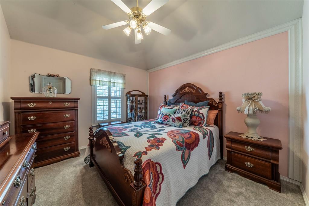 11621 Willow Springs Road Fort Worth, TX 76052 - Photo 13 of 35 a bedroom with a bed and a chandelier