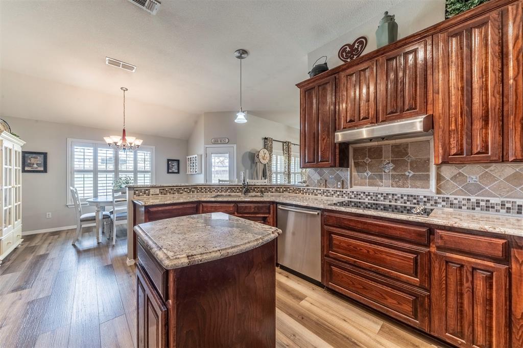 11621 Willow Springs Road Fort Worth, TX 76052 - Photo 5 of 35 a kitchen with granite countertop kitchen island wooden cabinets a counter top space and stainless steel appliances