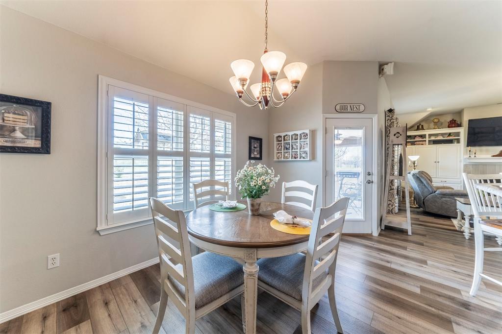 11621 Willow Springs Road Fort Worth, TX 76052 - Photo 6 of 35 a view of a dining room with furniture a chandelier and wooden floor