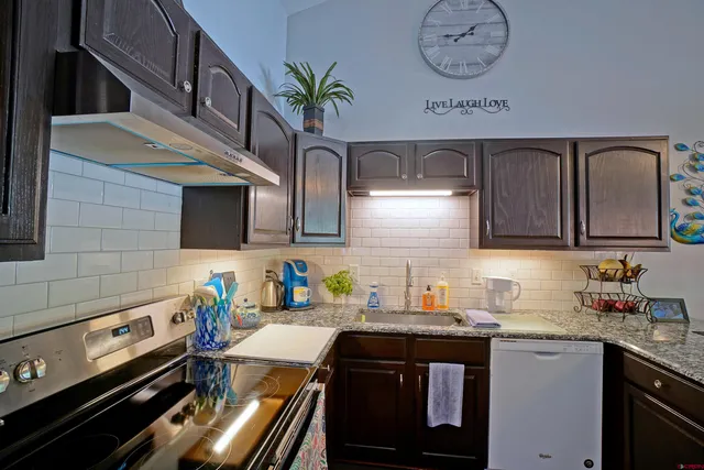 a kitchen with stainless steel appliances granite countertop a sink stove and cabinets