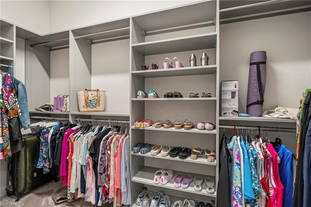 8795 Calypso Court Naples, FL 34113 - Photo 23 of 49 a view of walk in closet with clothes and shoes