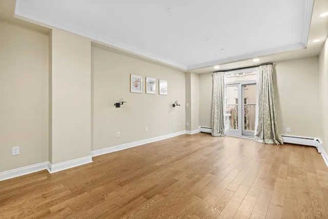 a view of an empty room with wooden floor