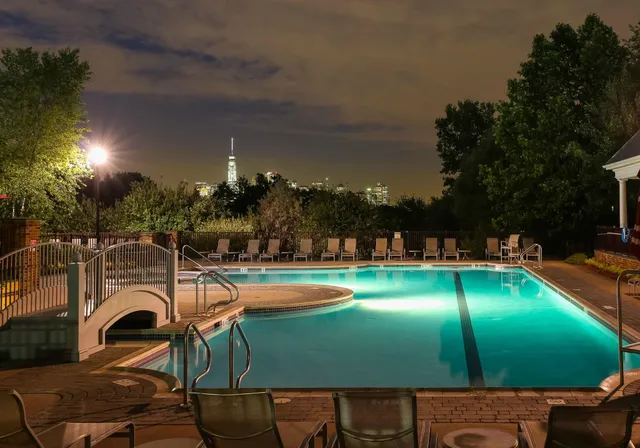 a view of a swimming pool with lawn chairs under an umbrella