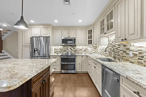 a kitchen with stainless steel appliances granite countertop a sink stove and refrigerator