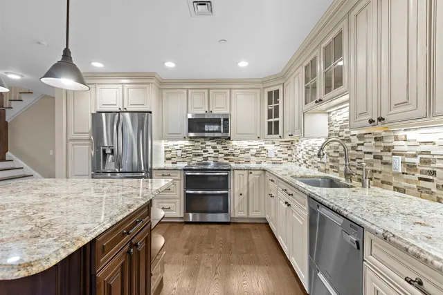 a kitchen with stainless steel appliances granite countertop a sink stove and refrigerator