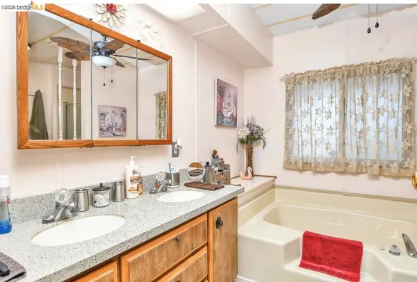 a bathroom with a granite countertop sink mirror and a bath tub