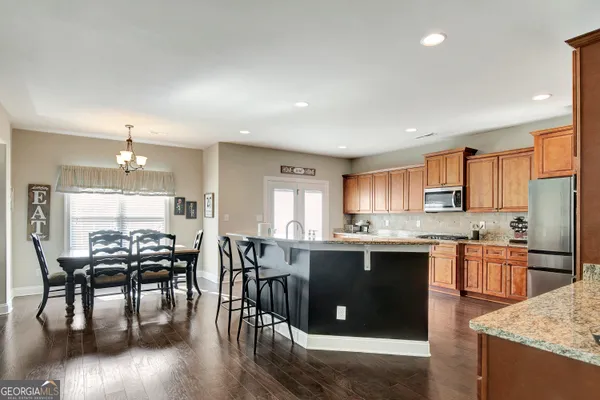 a kitchen with stainless steel appliances granite countertop wooden cabinets a sink and a stove