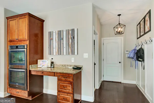 a large kitchen with stainless steel appliances granite countertop a lot of counter space and wooden floors