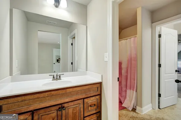 a bathroom with a sink a toilet and shower curtain