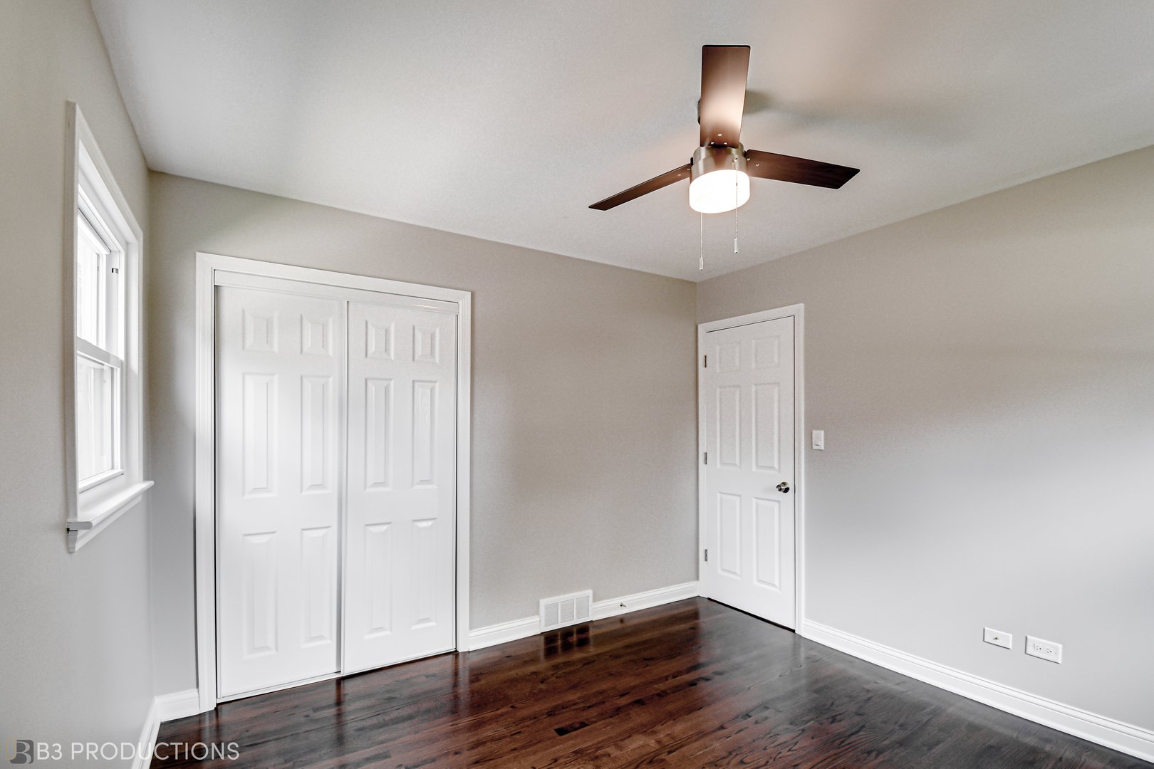 719 Jefferson Street Crete, IL 60417 - Photo 9 of 14 an empty room with wooden floor chandelier fan and windows