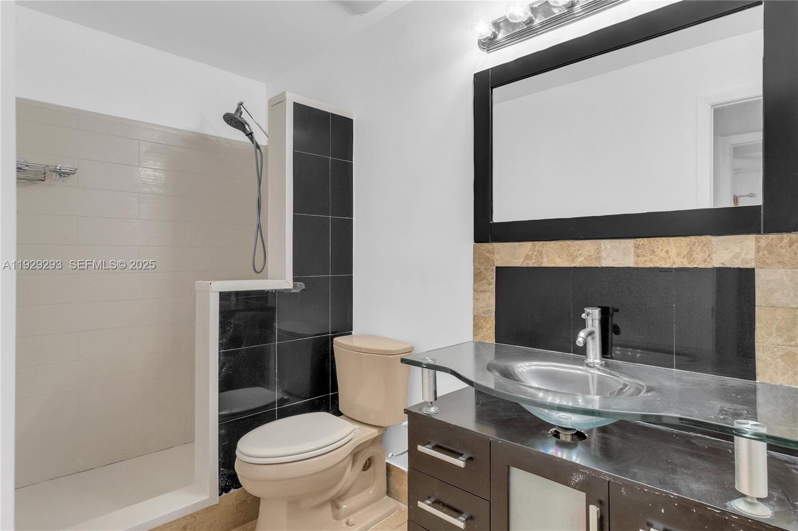 9415 West McNab Road, Unit 204 Tamarac, FL 33321 - Photo 15 of 20 a bathroom with a toilet sink and mirror