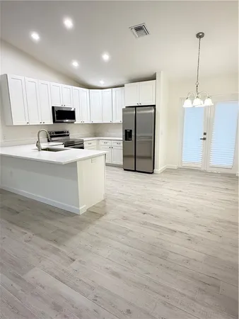 a kitchen with stainless steel appliances a refrigerator and a stove top oven
