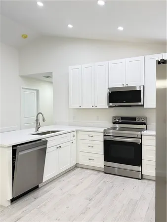 a kitchen with stainless steel appliances granite countertop a stove a sink and a microwave