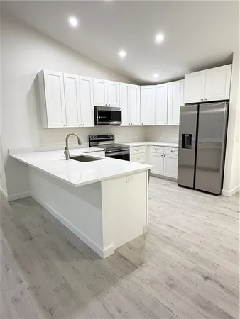 a kitchen with stainless steel appliances a refrigerator sink and microwave