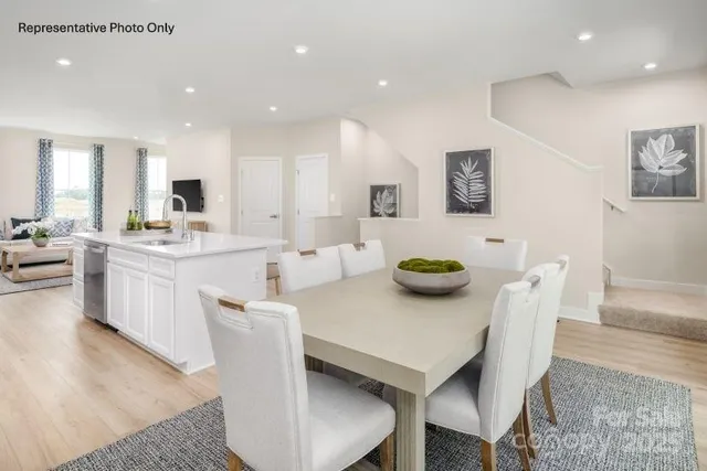 a kitchen with stainless steel appliances kitchen island dining table and chairs
