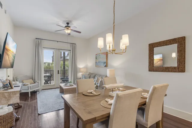a view of a dining room with furniture a chandelier and wooden floor