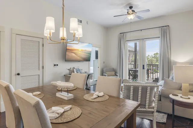 a view of a dining room with furniture a chandelier and wooden floor