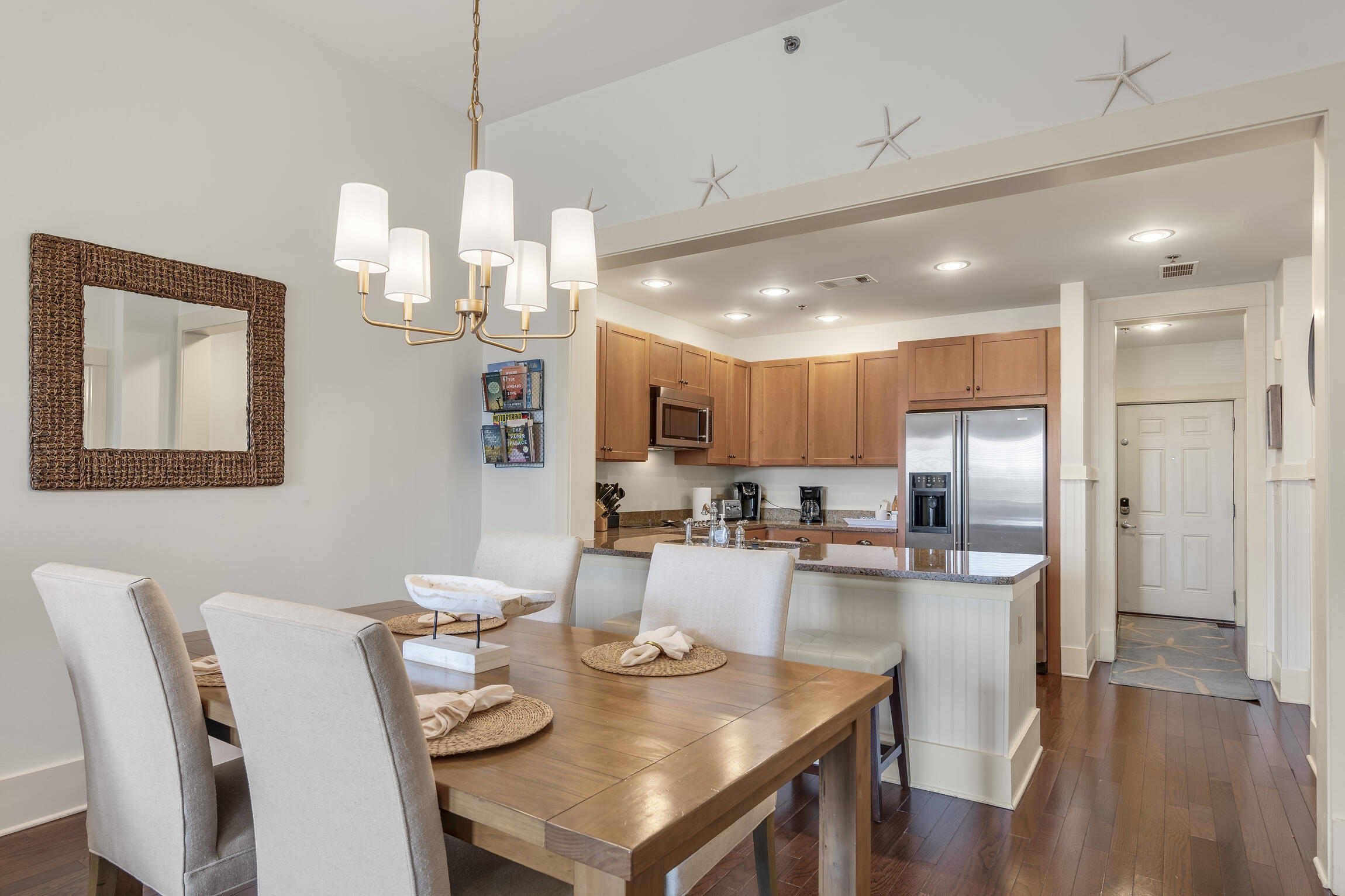 2050 West County Highway 30A, Unit M1219 Santa Rosa Beach, FL 32459 - Photo 6 of 47 a dining room with kitchen island stainless steel appliances furniture a chandelier and kitchen view