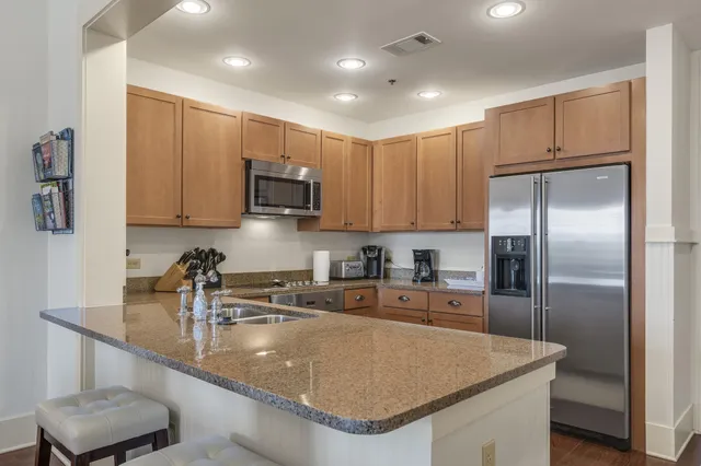 a kitchen with stainless steel appliances granite countertop a sink a stove and a refrigerator