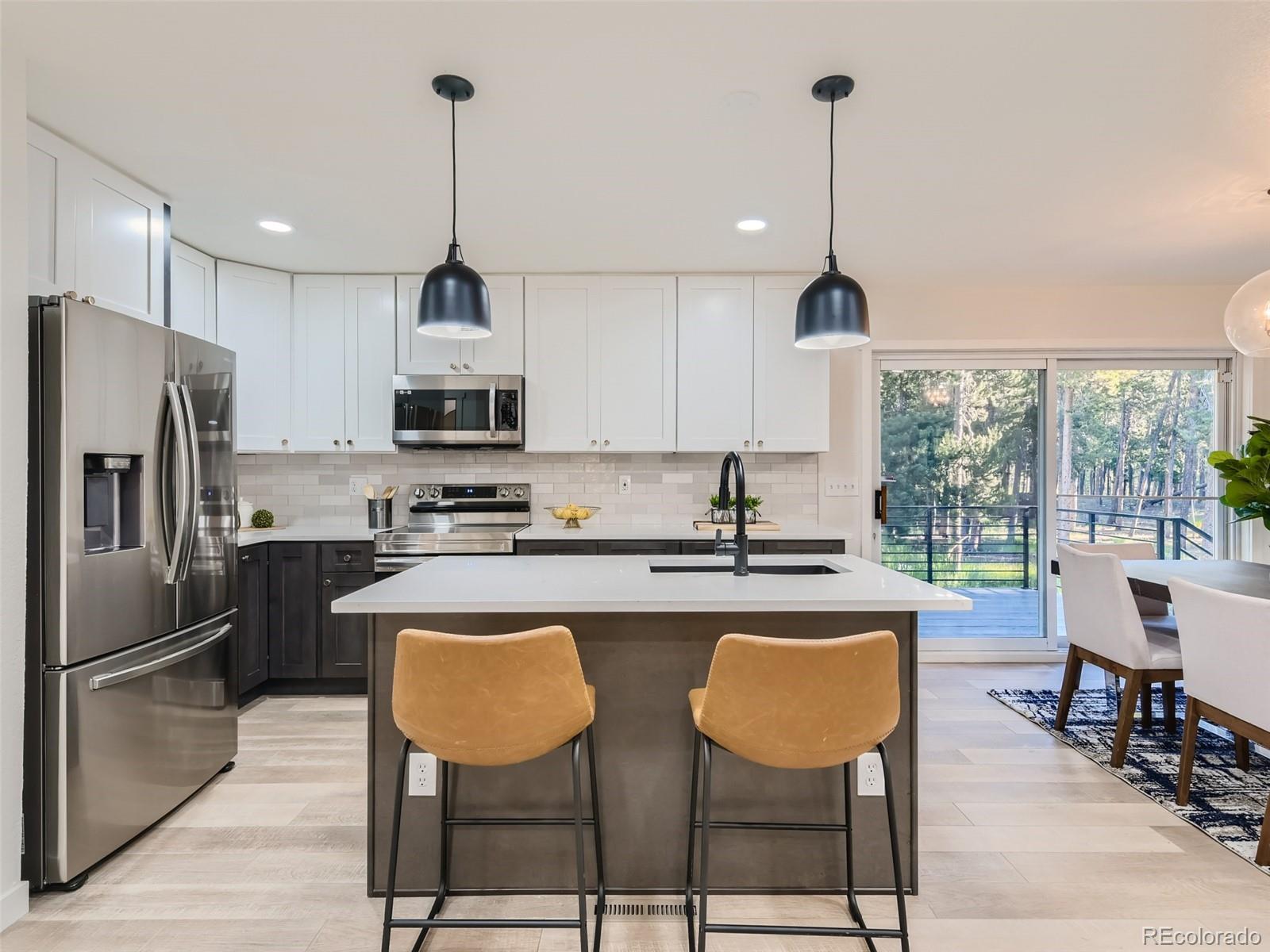 161 Gap Road Black Hawk, CO 80422 - Photo 5 of 28 a kitchen with stainless steel appliances granite countertop a stove a refrigerator a kitchen island a dining table and chairs