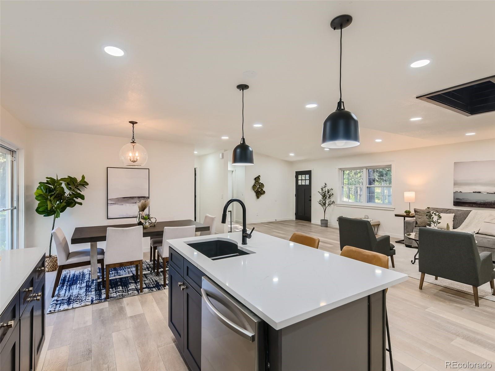 161 Gap Road Black Hawk, CO 80422 - Photo 7 of 28 a kitchen with a stove a sink a dining table and chairs with wooden floor