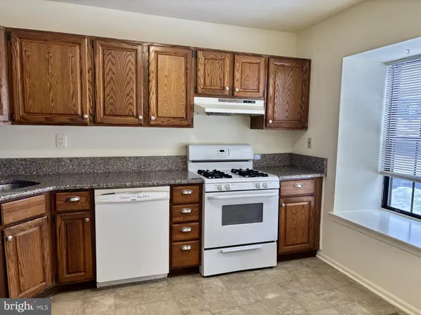 a kitchen with granite countertop a stove top oven sink and cabinets