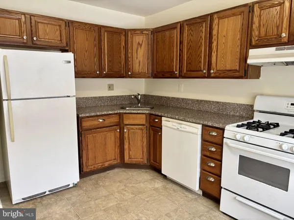 a kitchen with a stove sink and cabinets