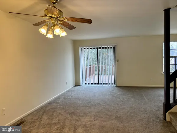 a view of a livingroom with a ceiling fan and window