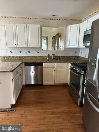 a kitchen with granite countertop a sink and stainless steel appliances