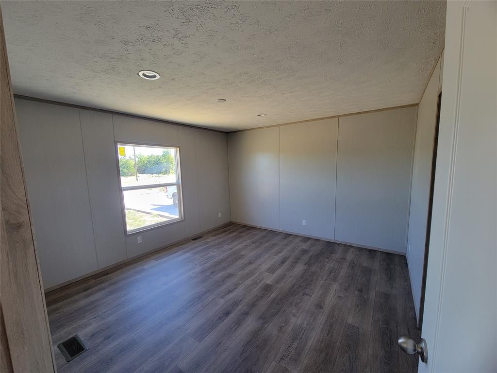 387 Duvall Street Bonham, TX 75418 - Photo 13 of 24 an empty room with wooden floor and windows
