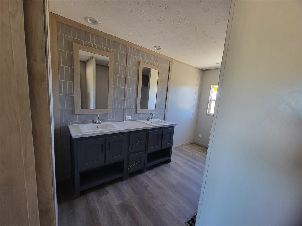 387 Duvall Street Bonham, TX 75418 - Photo 14 of 24 a bathroom with a sink and a mirror