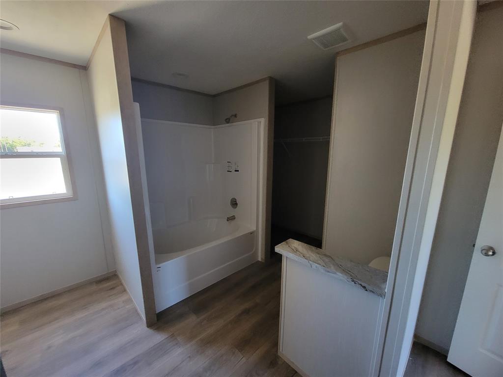 387 Duvall Street Bonham, TX 75418 - Photo 15 of 24 a bathroom with a bathtub