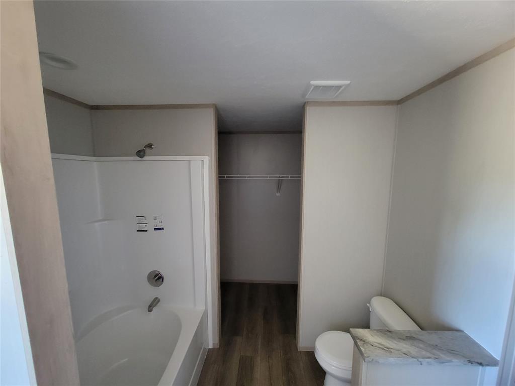 387 Duvall Street Bonham, TX 75418 - Photo 16 of 24 a bathroom with a bathtub and toilet