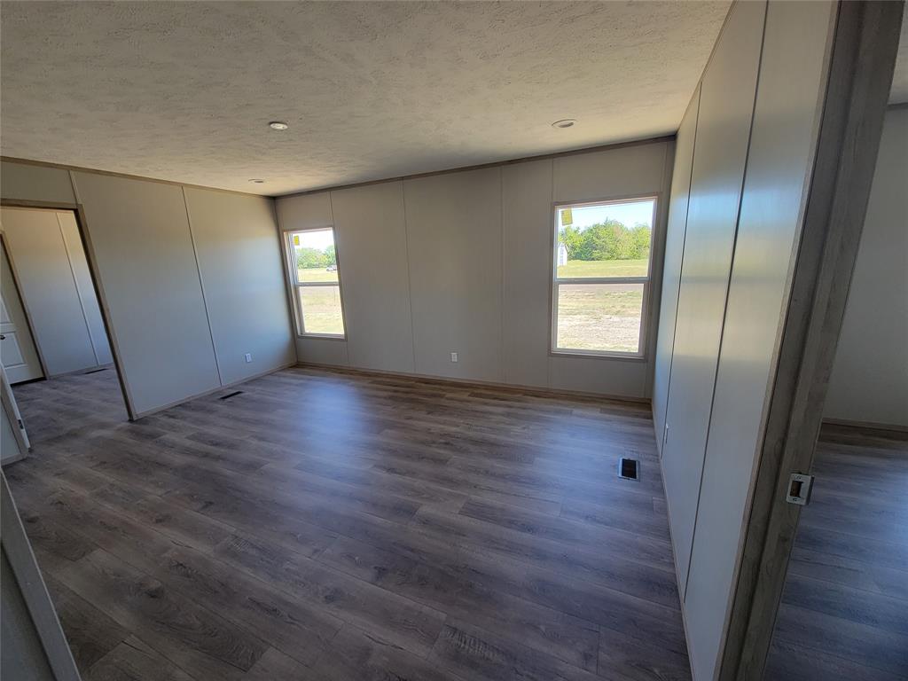 387 Duvall Street Bonham, TX 75418 - Photo 17 of 24 an empty room with wooden floor and windows