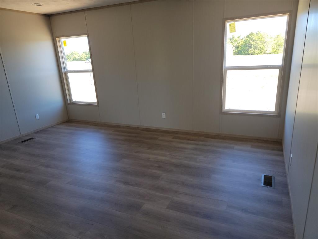 387 Duvall Street Bonham, TX 75418 - Photo 18 of 24 an empty room with wooden floor and windows