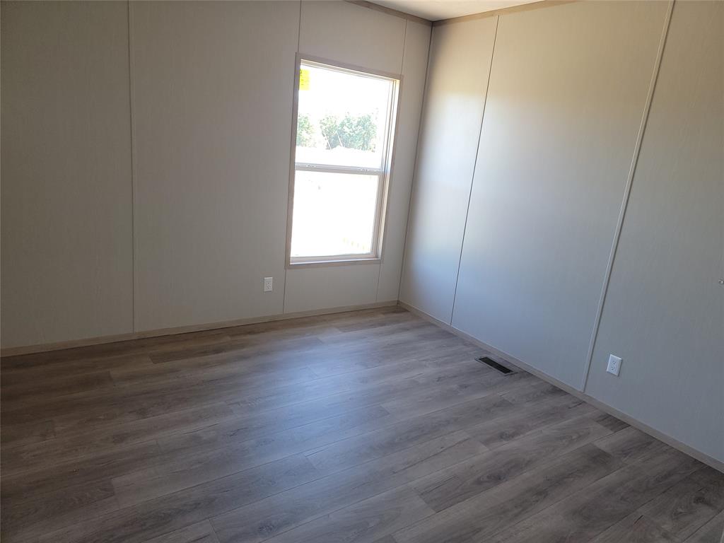387 Duvall Street Bonham, TX 75418 - Photo 19 of 24 an empty room with wooden floor and windows
