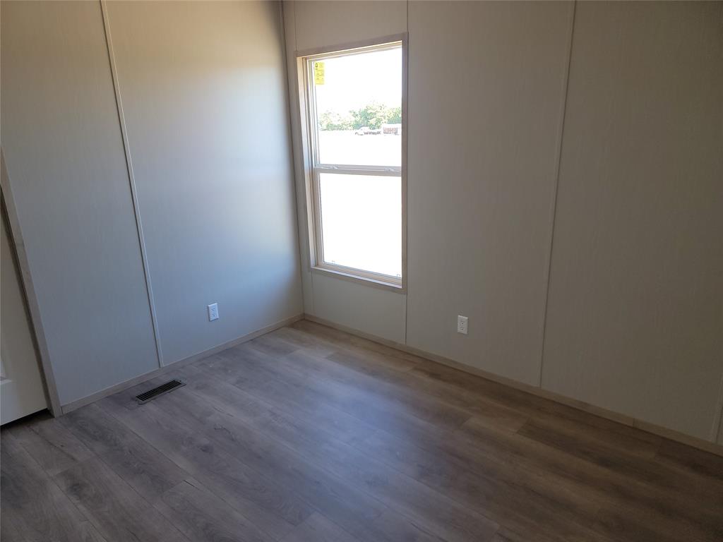 387 Duvall Street Bonham, TX 75418 - Photo 20 of 24 an empty room with wooden floor and windows
