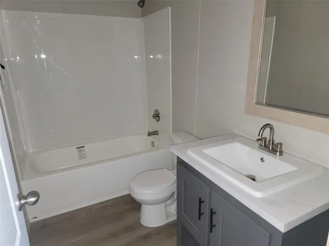 a bathroom with a sink toilet vanity and shower
