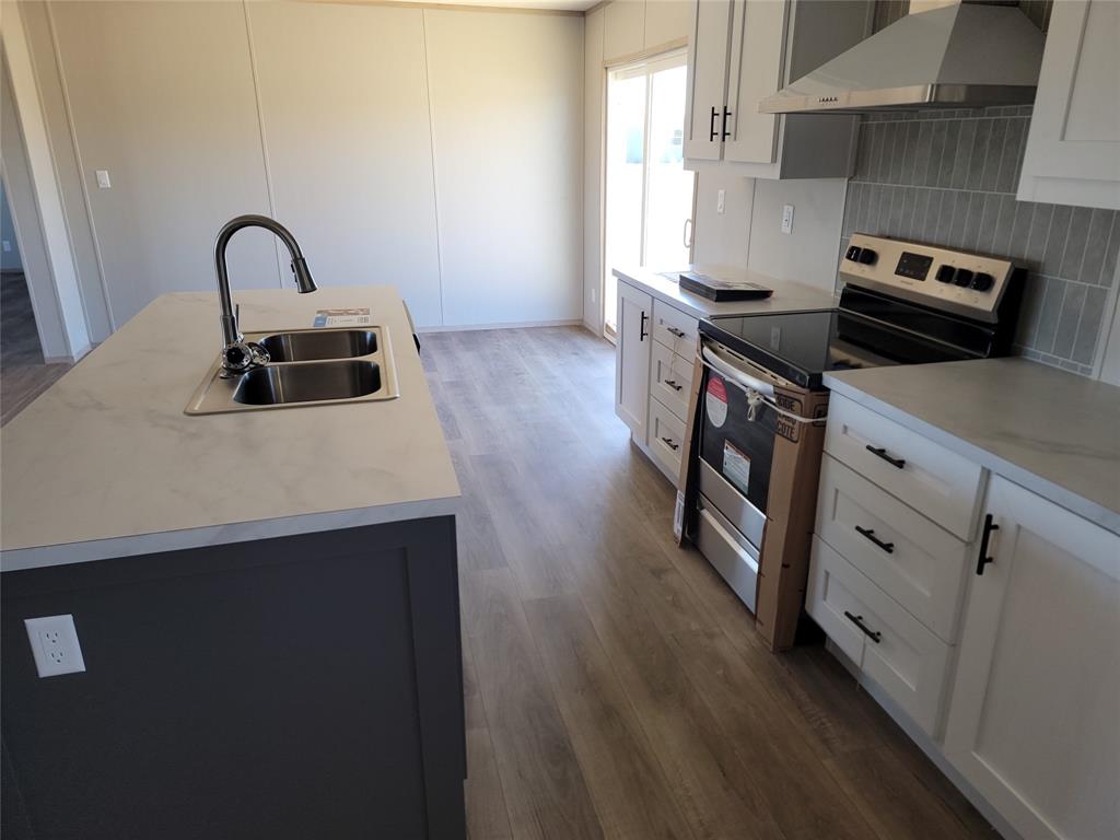387 Duvall Street Bonham, TX 75418 - Photo 24 of 24 a kitchen with kitchen island stainless steel appliances a sink and stove