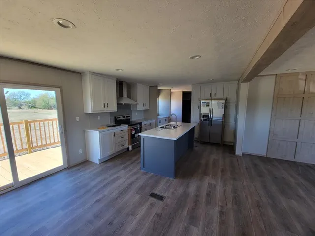 a large kitchen with a wooden floor and a large window