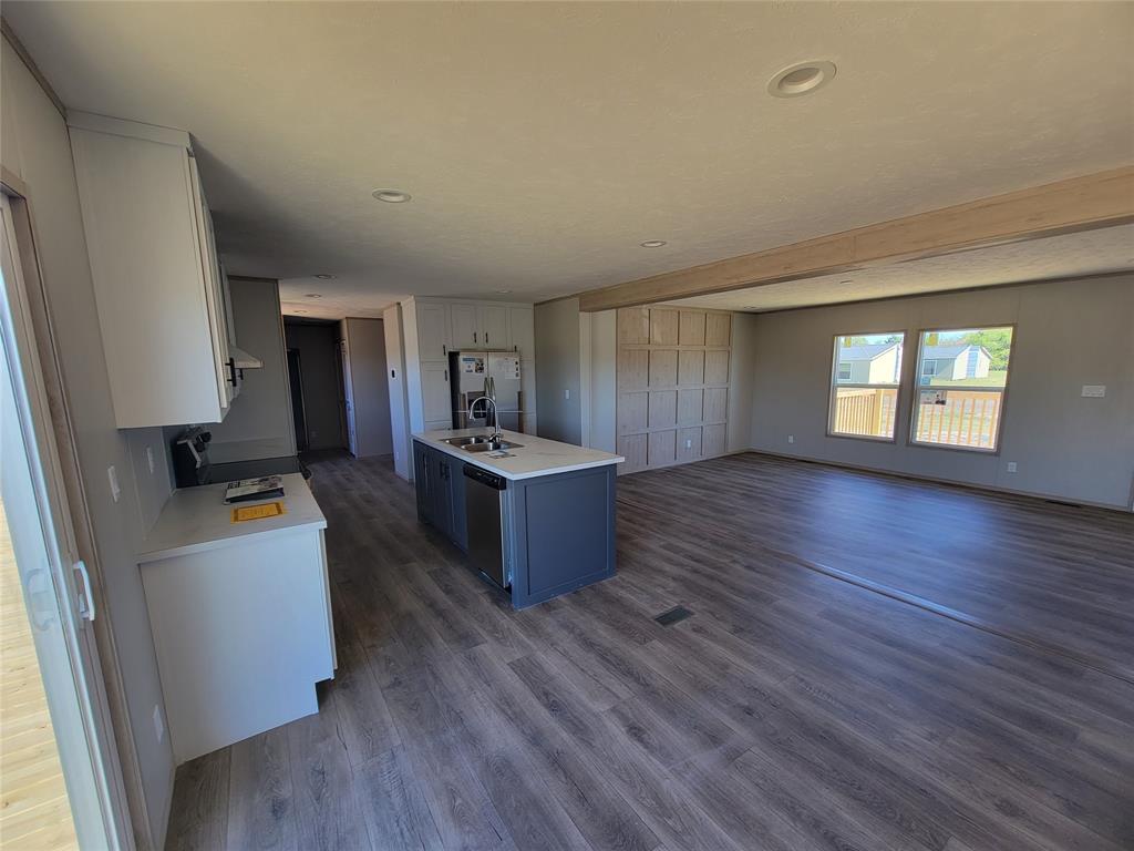 387 Duvall Street Bonham, TX 75418 - Photo 8 of 24 a living room with hard wood floors and a kitchen