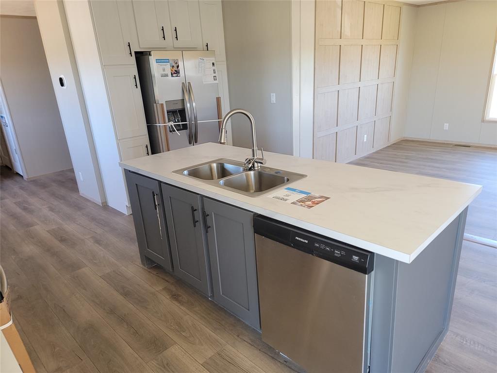 387 Duvall Street Bonham, TX 75418 - Photo 10 of 24 a kitchen with sink a refrigerator and washer