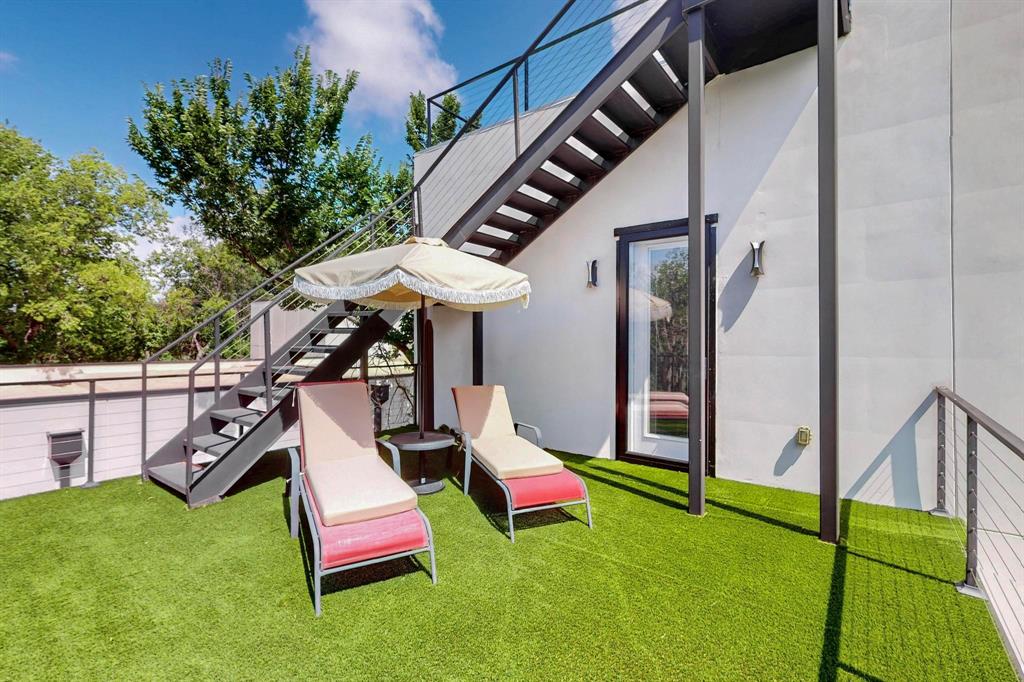 3946 North Cresthaven Road Dallas, TX 75209 - Photo 30 of 38 Rooftop deck featuring artificial turf flooring, a metal staircase with cable railings, and a glass-paneled exterior door