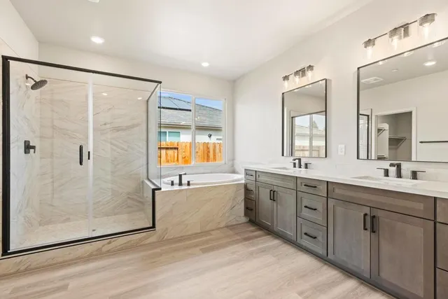 a large bathroom with a double vanity sink toilet and shower