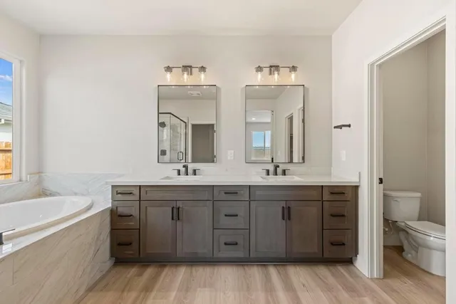 a spacious bathroom with double vanity two mirror and a bathtub