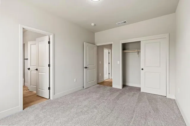 an empty room with closet and a bathroom
