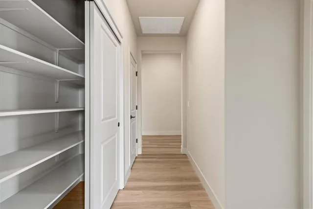 a view of a hallway with wooden floor and entryway